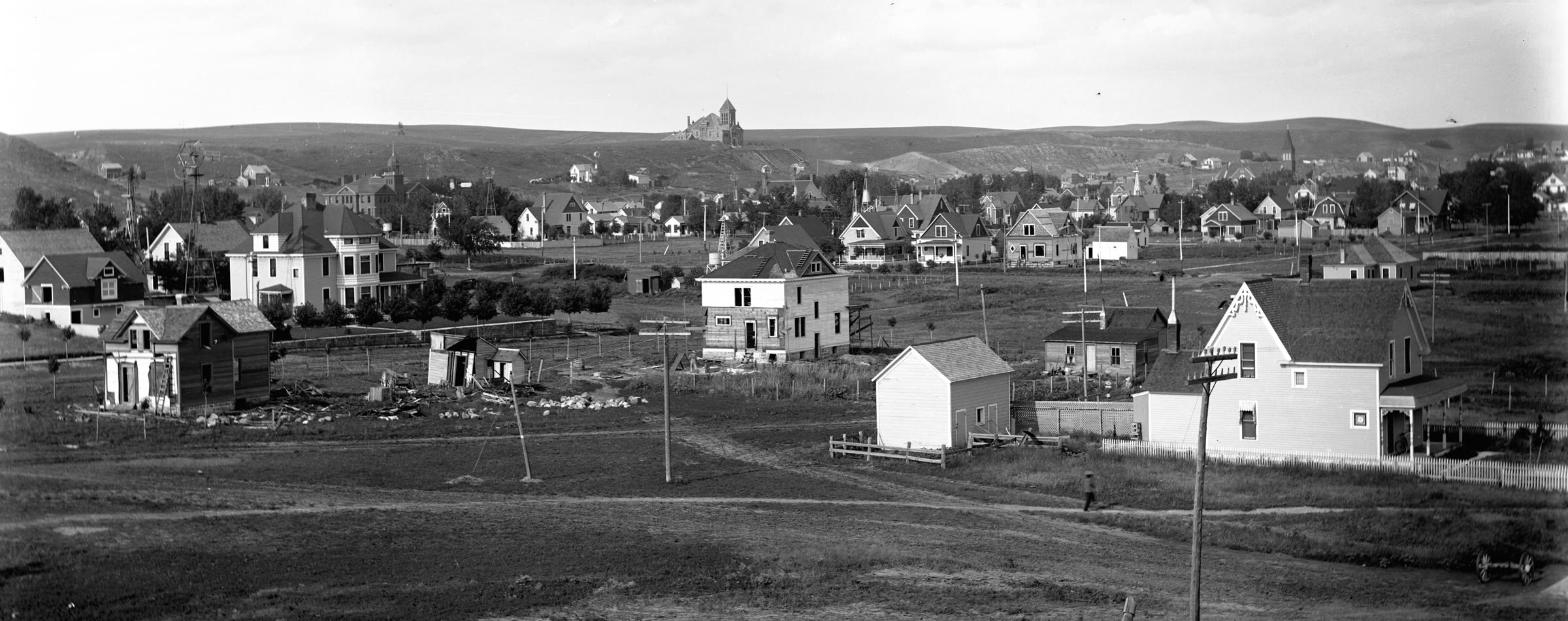 A panoramic view of Mandan from the west, with homes in the foreground and churches rising along the distant ridge