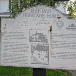 A weathered Heritage Home sign for the J. H. Newton Home