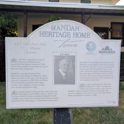 A Heritage Home sign for the Shaw Home with the house behind it