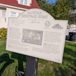 A Heritage Home sign for the Braxmeier Home with the house behind it