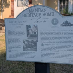A Heritage Home sign for the Flakker Home with the house behind it