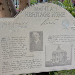 A weathered Heritage Home sign for the Lanterman Home at 303 3rd Avenue NW