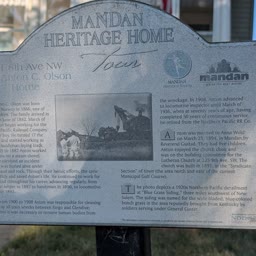A weathered Heritage Home sign for the Anton C. Olson Home
