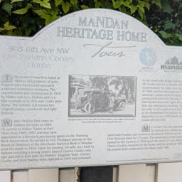 A weathered Heritage Home sign for the Parkins-Cooley Home