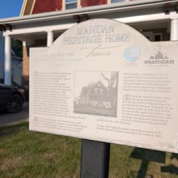 A Heritage Home sign for the Herman Swanson Home with the house behind it